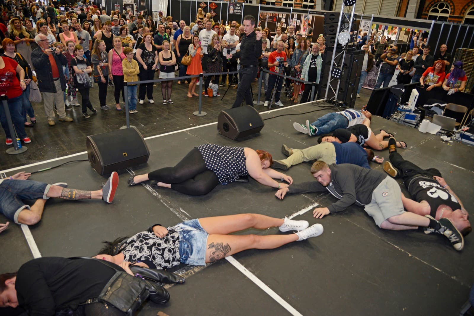 Hypnotised volunteers lying on the floor during a stage hypnosis show